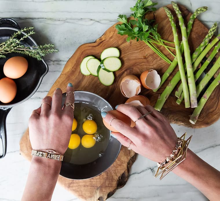 Hands preparing a vibrant salad, showcasing the healthy cooking skills taught in our pregnancy nutrition workshops.